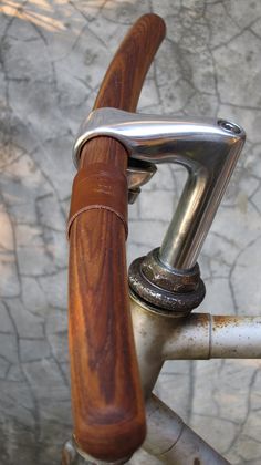 the handlebars on this bike are made from wood and metal, with a silver finish