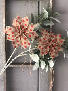 two red and white flowers are hanging on a door