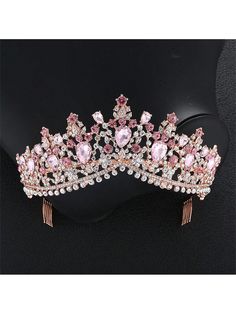 a tiara with pink and white stones on it's headpiece, sitting on top of a black mannequin