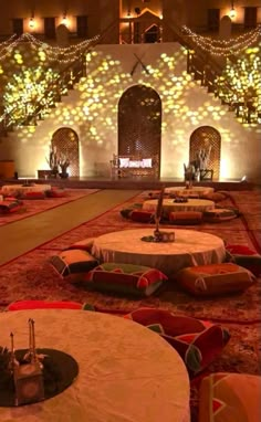 tables and chairs are set up in the middle of a room with lights on it