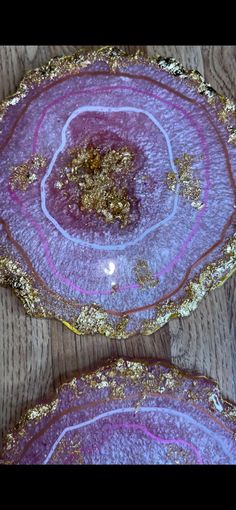 three purple and gold plates on a wooden table