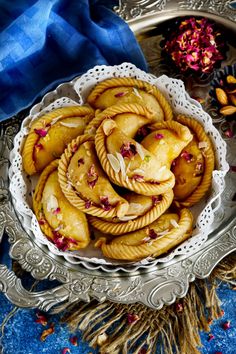 a bowl filled with cookies on top of a blue and white table cloth next to dried flowers