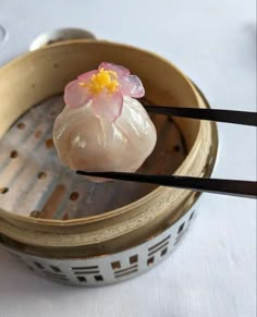 two chopsticks sticking out of a dumpling with a flower on it,