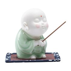 a little buddha figurine holding a stick