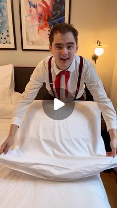 a man is standing on top of a bed with an unmade sheet in front of him