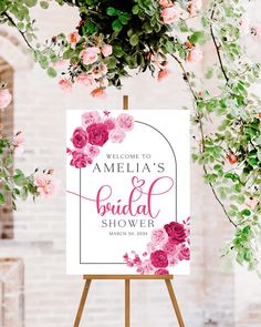 a welcome sign with pink flowers and greenery in the background for an elegant bridal shower