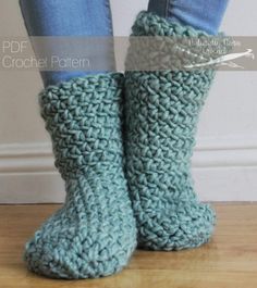 a pair of blue crocheted slippers sitting on top of a wooden floor