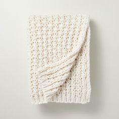 a white knitted blanket laying on top of a table