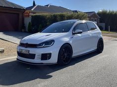 a white car parked in front of a house