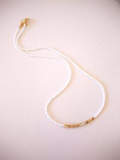 There is something different about this necklace. First of all, there are not too many left. Second, it has THE perfect amount of sparkle, that sparkle that comes to life when you move, converse, dance, or while you are having a romantic dinner. This necklace is made with white seed beads and gold Swarovski accent stones. It is as minimalist and delicate as it gets! Choose size 14" at checkout for choker style, or choose the length that suits you best! Also available with other accent color ston White Beaded Chain Necklaces For Festivals, White Beaded Necklace For Festivals, White Beaded Necklace For Festival, Dainty Necklaces With Tiny Beads For Festivals, White Bohemian Jewelry With Delicate Chain, White Bohemian Beaded Necklace With Tiny Beads, White Beaded Bracelets With Gold Beads For Festivals, White Necklaces With Spacer Beads For Festival, Dainty Tiny Beads Necklaces For Festival