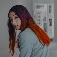 a woman with long red hair standing in a kitchen