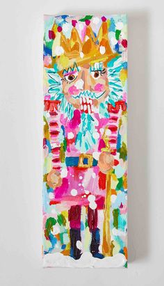 a colorful painting on a white wall depicting a nutcracker wearing a crown and holding a candy cane