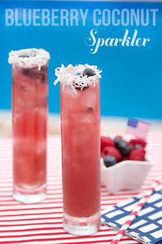 two tall glasses filled with blueberry coconut spritkles on top of a red and white table cloth