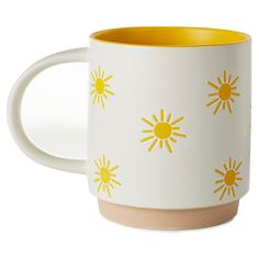 a yellow and white coffee mug with the sun pattern on it's side, in front of a white background