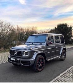 a mercedes g - class is parked on the street