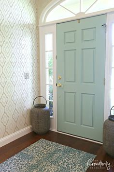 a blue front door with two baskets on the floor and a rug in front of it