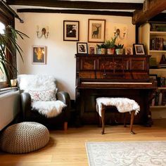 a living room filled with furniture and a piano in front of a window next to a rug