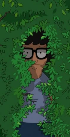 a man with glasses is hiding in the bushes