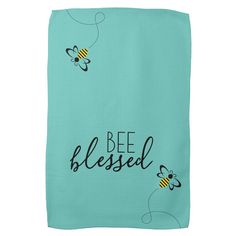 a teal towel with two bees on it and the words bee blessed written in black ink