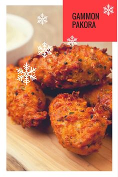 some food is on a wooden board with snowflakes around it and the words gammon pakora written in white