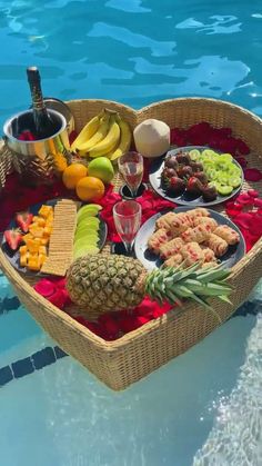 a heart shaped basket filled with food next to a pool