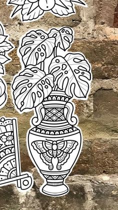 some stickers that are on the side of a brick wall with flowers in a vase