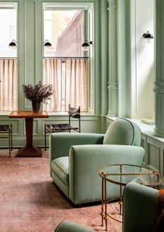 a living room filled with green furniture and lots of window sill covered in curtains