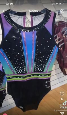 a leotard shirt is hanging on a rack in a store with other leotards