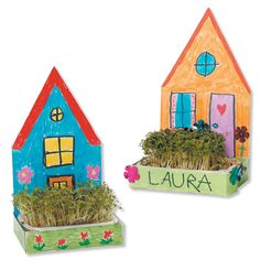 two cardboard houses with flowers and plants in them