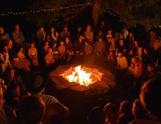 a group of people sitting around a fire pit