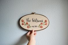 a person holding up a wooden sign that says the willows on it's side