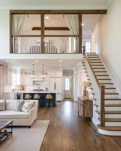 a living room filled with furniture and a stair case in front of a white couch