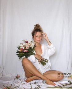 a woman sitting on the floor with flowers in her hair