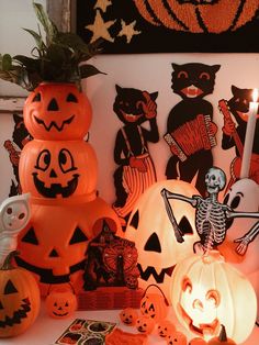 pumpkins and other halloween decorations are displayed on a table in front of a wall