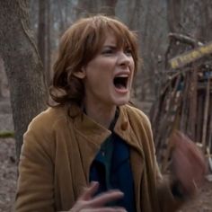 a woman with her mouth open in the woods