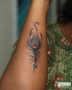 a woman's arm with a peacock tattoo on it