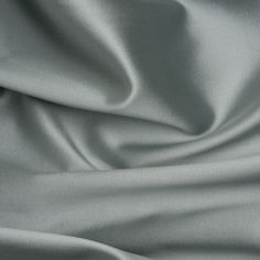 a close up view of a plain silver fabric with very soft folds and wrinkles