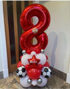 the number six balloon sculpture is decorated with soccer balls