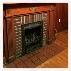 an old fireplace with wood paneling in a living room