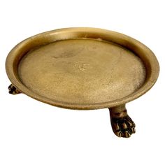 an antique brass plate with paw prints on the bottom and feet resting on it's side