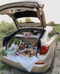 the back end of a car with flowers and other items in it's trunk