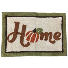 a door mat that says home with a pumpkin on the front and green trimming