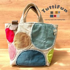 a handbag made out of fabric with different colored circles on the front and sides