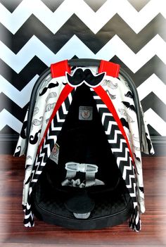 a baby car seat in front of a chevron wall with black and white stripes