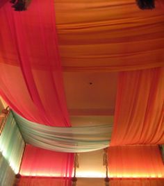 the ceiling is decorated with colorful drapes