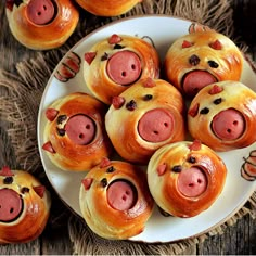 pigs in bread rolls on a plate with holly branches and berries around them, ready to be eaten