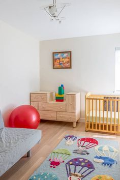 a baby's room with a couch, crib and toys on the floor