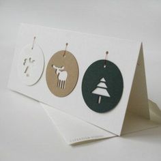 three cards with different designs on them and one has a christmas ornament hanging from it