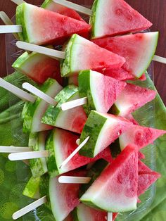 watermelon and toothpicks are arranged on a green leafy platter