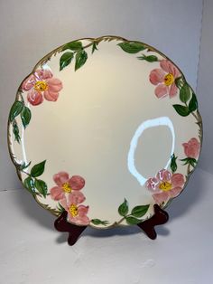 a decorative plate with pink flowers on it